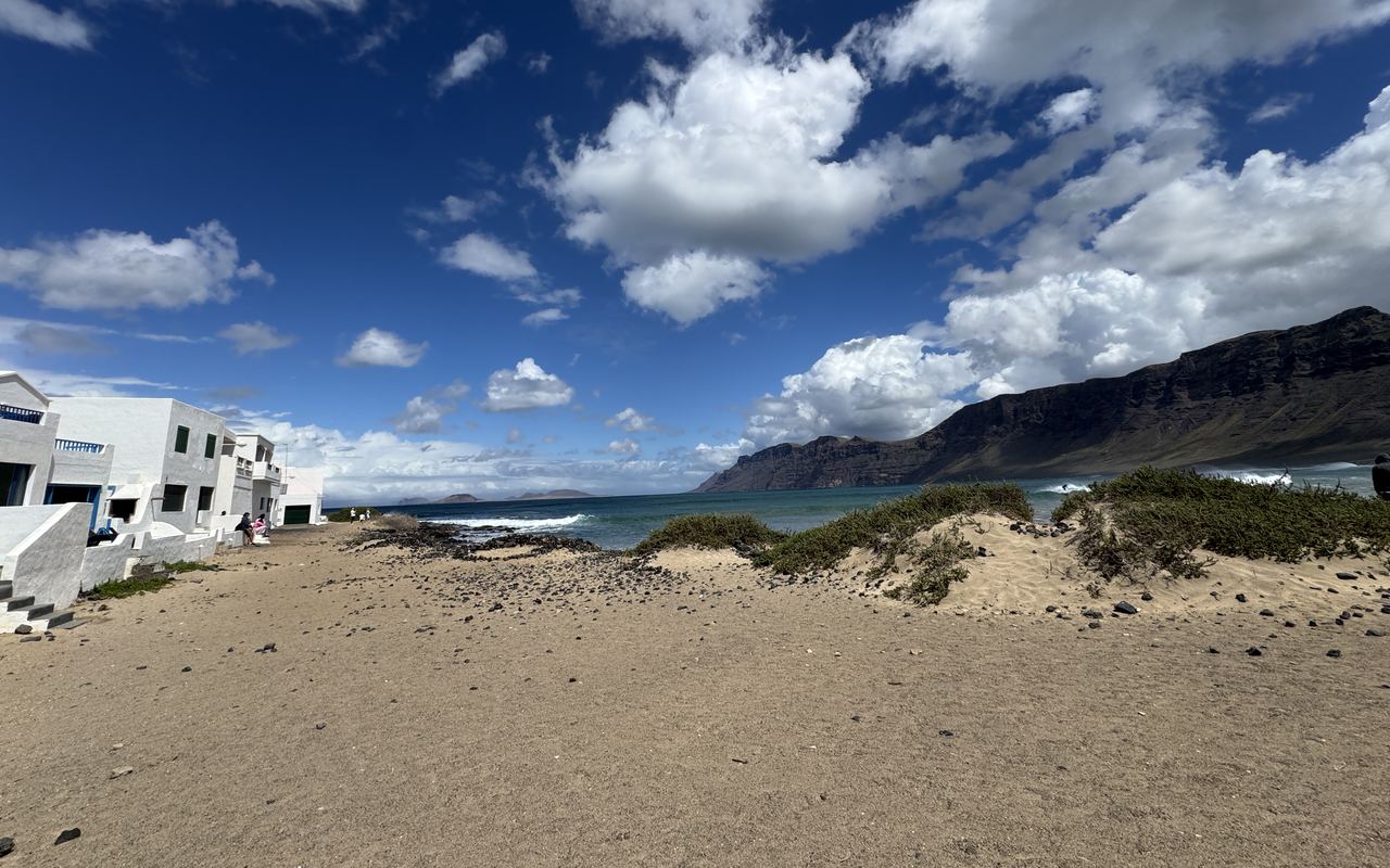 White houses on the beach at Caleta de Famara in front of the cliffs