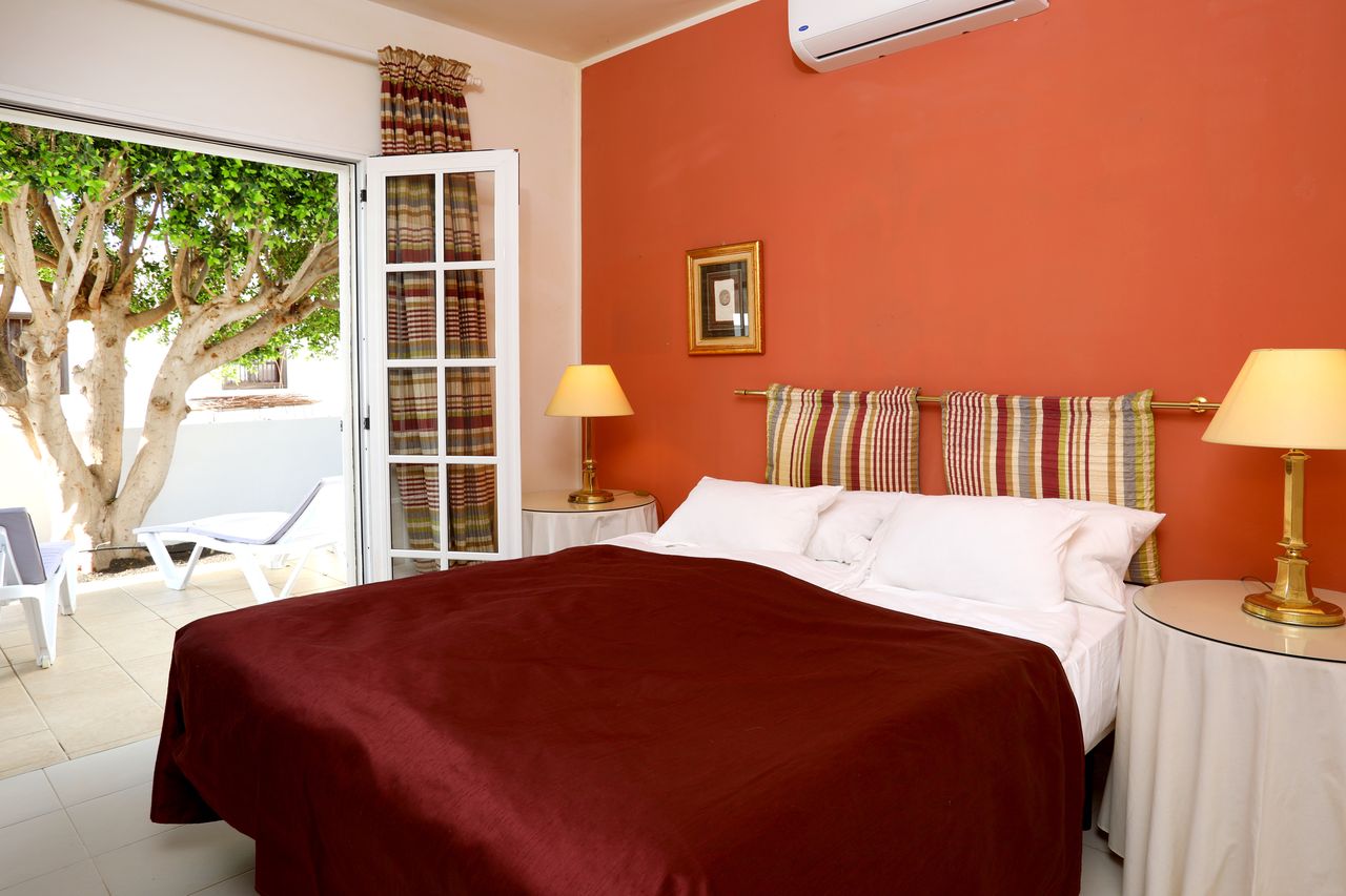 The red bedroom with double bed and a view of the garden