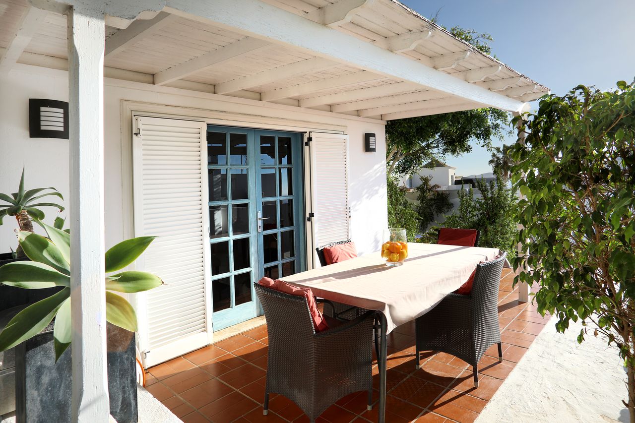 Dining table under the white pergola on the terrace